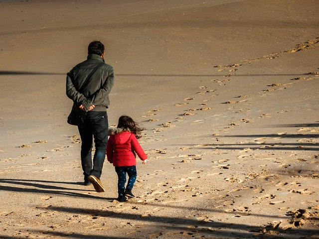 砂浜を歩く父と子